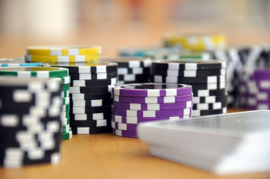 Chip poker berwarna warni bertumpuk di depan kartu